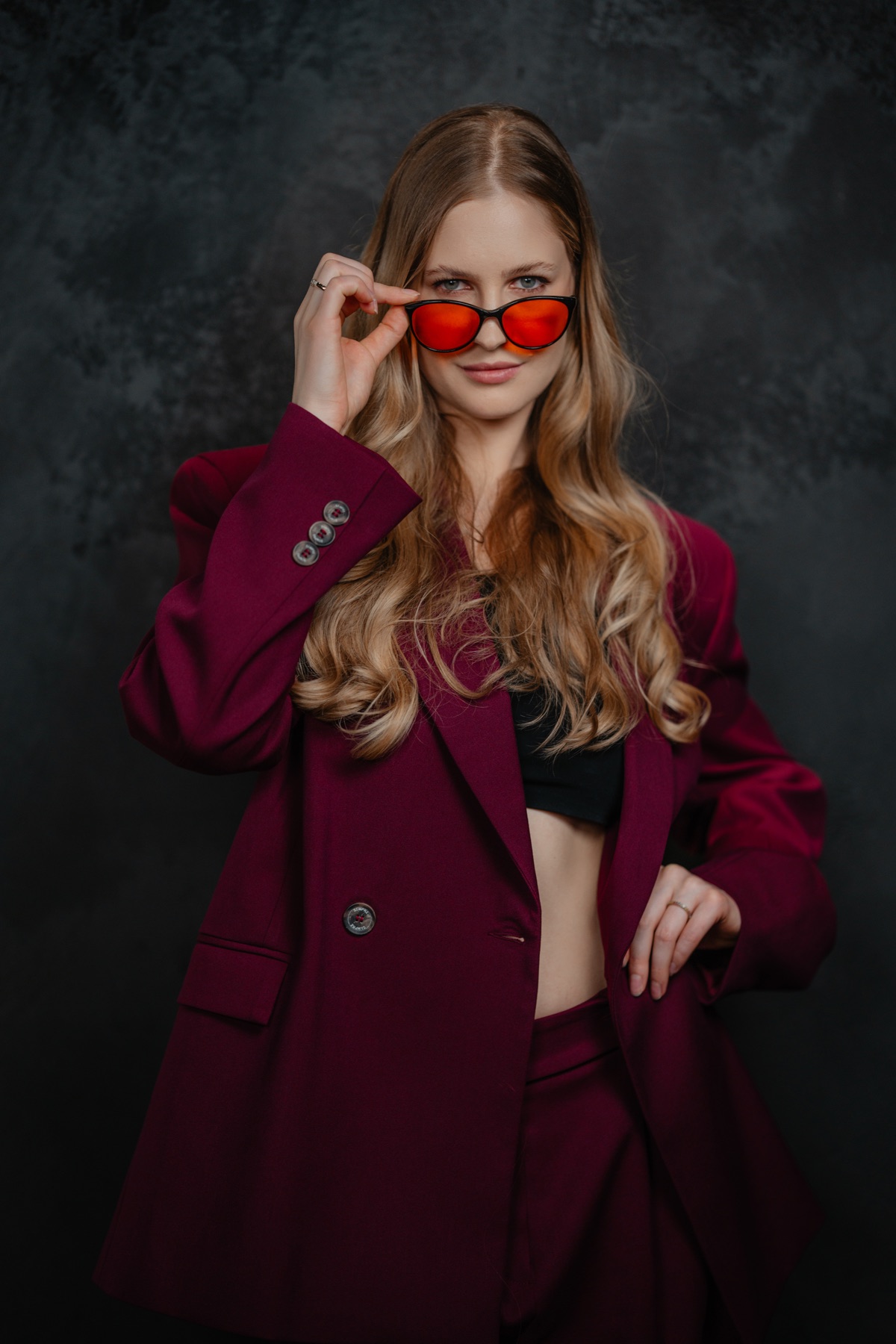 Julianna w bordowym garniturze i czerwonych okularach